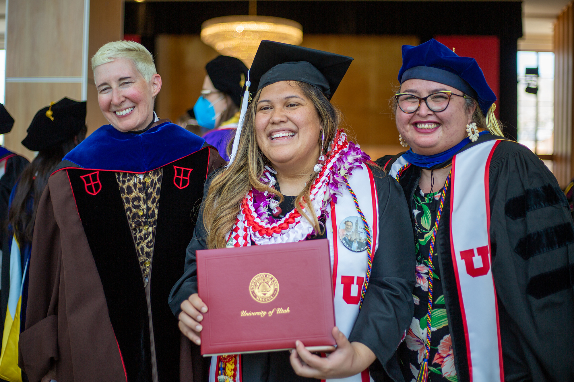 Dean Stockton and Professor Robinson pose and smile with a recent Transform graduate