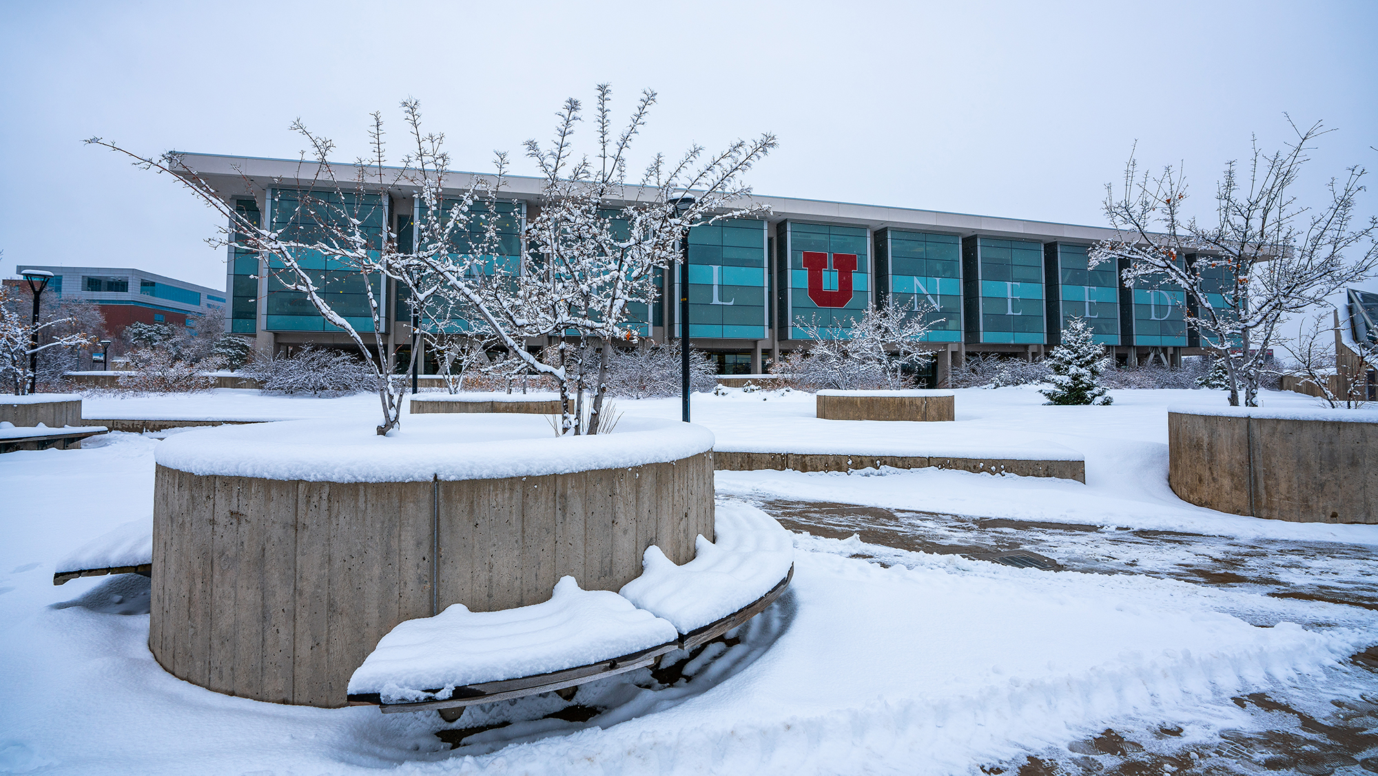 the exterior of the J. Willard Marriott Library and surrounding landscape covered in snow